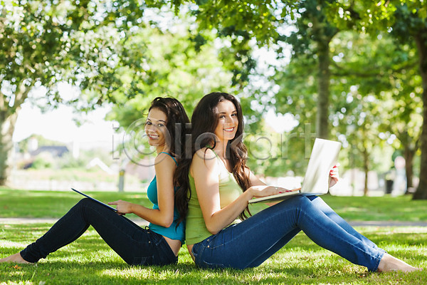 우정 함께함 행복 20대 두명 백인 여자 청년 JPG 포토 해외이미지 공원 공책 노트북 미소(표정) 앉기 야외 응시 자연 잔디 초록색 컴퓨터 태블릿 태양 터치 해외202004 햇빛