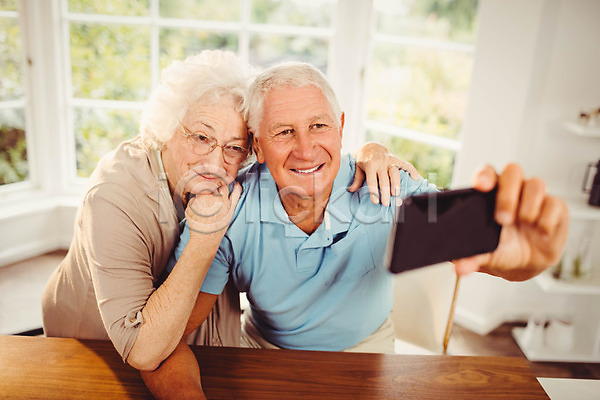 함께함 행복 70대 남자 노년 노인만 두명 백인 여자 JPG 포토 해외이미지 가정 노후 라이프스타일 미소(표정) 보여주기 스마트폰 스크린 실내 아파트 잡기 주택 커플 포즈 해외202004