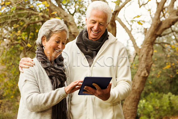 사랑 함께함 행복 60대 70대 남자 노년 노인만 두명 백인 여자 JPG 포토 해외이미지 가을(계절) 겨울옷 공원 라이프스타일 목도리 미소(표정) 백발 야외 자연 초록색 커플 태블릿 터치스크린 해외202004