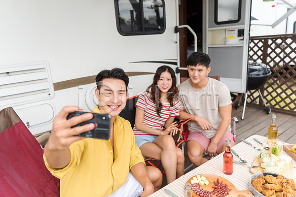 즐거움 행복 휴식 20대 남자 성인만 세명 여자 한국인 JPG 앞모습 포토 강원도 들기 미소(표정) 사진촬영 상반신 셀프카메라 스마트폰 앉기 야외 여름(계절) 여행 주간 친구 카라반 캠핑 캠핑장 휴가