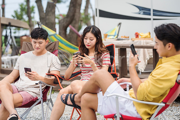 즐거움 행복 휴식 20대 남자 성인만 세명 여자 한국인 JPG 앞모습 옆모습 포토 강원도 들기 스마트폰 앉기 야외 여름(계절) 여행 전신 주간 친구 카라반 캠핑 캠핑장 휴가