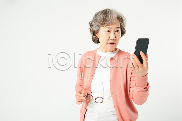 당황 60대 노년 노인여자한명만 여자 한국인 한명 JPG 앞모습 포토 건강 놀람 눈건강 들기 보이스피싱 상반신 서기 스마트폰 스튜디오촬영 시력 실내 실버라이프 안경 액티브시니어 오팔세대 할머니 흰배경