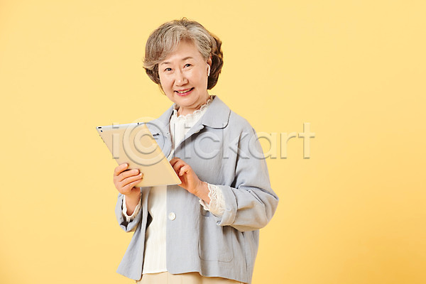 즐거움 60대 노년 노인여자한명만 여자 한국인 한명 JPG 앞모습 포토 노란배경 뉴식스티 들기 무선이어폰 미소(표정) 상반신 서기 스튜디오촬영 실내 실버라이프 액티브시니어 오팔세대 이벤트 이어폰 캐주얼 태블릿 터치 할머니