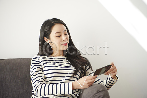 즐거움 30대 성인 성인여자한명만 여자 한국인 한명 JPG 앞모습 포토 가족 단절 상반신 소파 스마트폰 실내 앉기 영상 응시 이어폰
