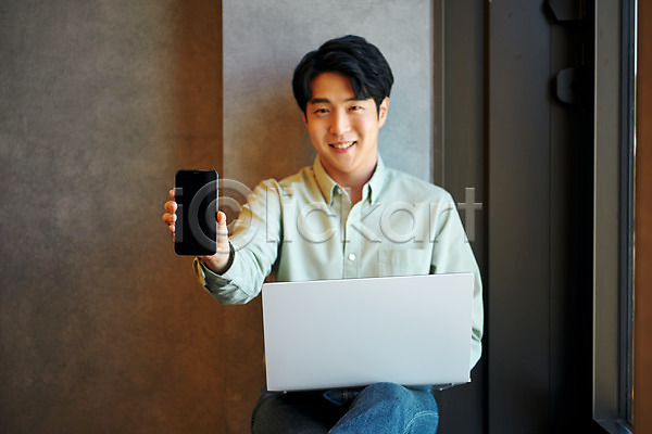 20대 남자 성인 성인남자한명만 한국인 한명 JPG 앞모습 포토 노트북 들기 라운지 미소(표정) 보여주기 비즈니스 비즈니스맨 사무실 상반신 스마트폰 실내 앉기 업무 직장 창업 회사