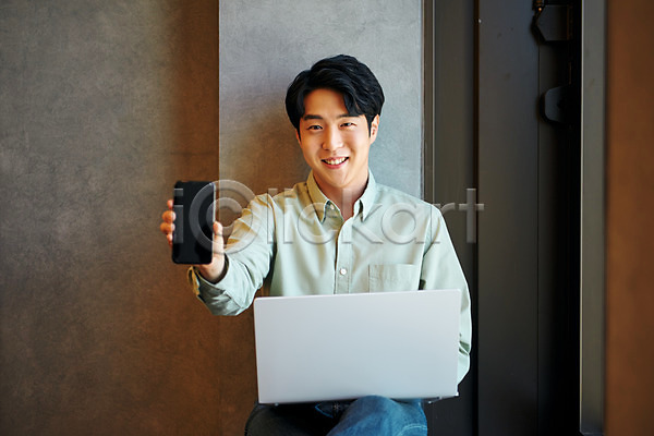 20대 남자 성인 성인남자한명만 한국인 한명 JPG 앞모습 포토 노트북 들기 라운지 미소(표정) 보여주기 비즈니스 비즈니스맨 사무실 상반신 스마트폰 실내 앉기 업무 직장 창업 회사