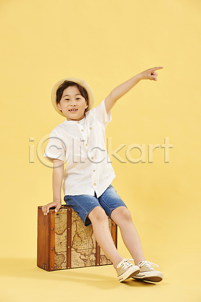 즐거움 휴식 남자 소년 소년한명만 어린이 한국인 한명 JPG 앞모습 포토 가리킴 노란배경 미소(표정) 스튜디오촬영 앉기 여행 여행가방 전신 취미
