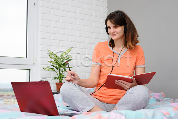 백인 성인 성인여자한명만 여자 한명 JPG 앞모습 포토 해외이미지 교육 노트북 들기 앉기 이어폰 전신 책 침대 침실 학생 해외202007 헤드폰