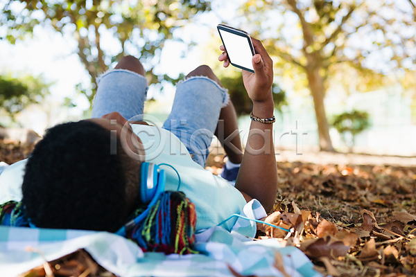 남자 성인 성인남자한명만 한명 흑인 JPG 뒷모습 아웃포커스 포토 해외이미지 공원 눕기 돗자리 들기 소풍 스마트폰 야외 전신 주간 해외202008 헤드셋