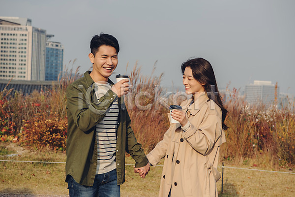 다정 20대 남자 성인 성인만 여자 한국인 JPG 앞모습 포토 가을(계절) 공원 남산 남산공원 데이트 들기 미소(표정) 상반신 서기 손잡기 야외 주간 커플 커피 트렌치코트