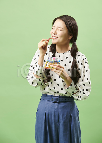 즐거움 20대 사람 성인 성인여자한명만 여자 한국인 한명 JPG 앞모습 포토 눈감음 뉴트로 들기 맛있는 먹기 모양 민트색배경 복고 상반신 서기 스튜디오촬영 실내 웃음 유행 젤리 지렁이 포즈