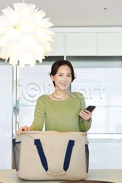 30대 사람 성인 성인여자한명만 여자 한국인 한명 JPG 앞모습 포토 들기 라이프스타일 미소(표정) 배송 상반신 새벽배송 쇼핑 스마트폰 실내 응시 짐가방 택배 흰배경