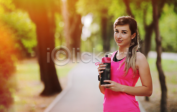 사람 성인 성인여자한명만 여자 한명 JPG 아웃포커스 옆모습 포토 해외이미지 건강 공원 달리기 들기 물병 미소(표정) 상반신 숲 야외 운동복 조깅 주간