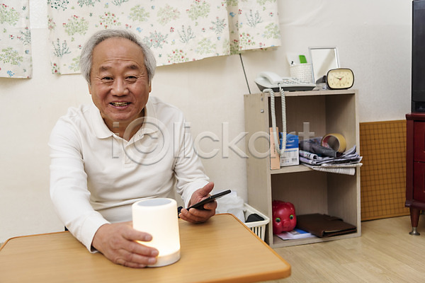 70대 남자 노년 노인남자한명만 한국인 한명 JPG 앞모습 포토 AI(인공지능) 고령화 독거노인 들기 상반신 스마트폰 스피커 실내 실버라이프 앉기 웃음 잡기 할아버지
