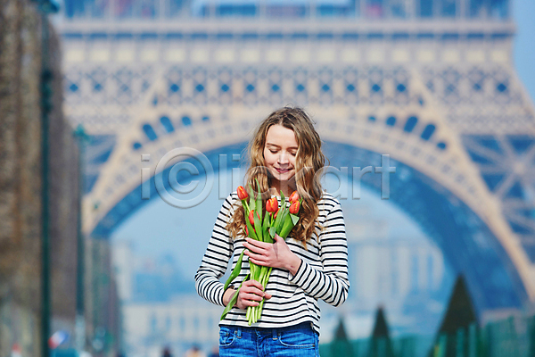 백인 성인 성인여자한명만 여자 한명 JPG 아웃포커스 앞모습 포토 해외이미지 거리 꽃다발 눈감음 들기 미소(표정) 상반신 야외 에펠탑 주간 튤립 파리(프랑스)