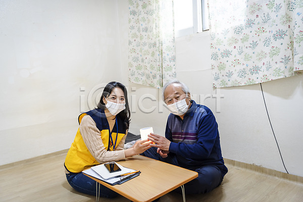 노인복지 봉사 30대 70대 남자 노년 두명 성인 여자 한국인 JPG 앞모습 포토 AI(인공지능) 독거노인 들기 마스크 보살핌 사회복지사 상반신 설명 스피커 실내 앉기 응시 전신 책상