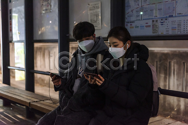 10대 남자 두명 십대만 여자 청소년 한국인 JPG 앞모습 포토 겨울 귀가 들기 마스크 버스정류장 상반신 스마트폰 시청(보고들음) 앉기 야간 야간자율학습 야외 온라인강의 이어폰 책가방 코로나바이러스
