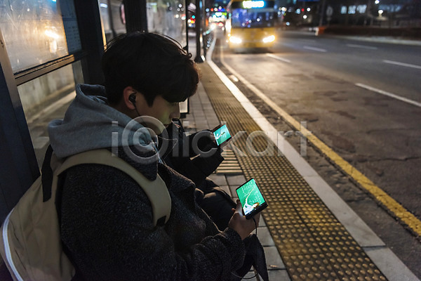 10대 남자 두명 십대만 여자 청소년 한국인 JPG 옆모습 포토 겨울 귀가 들기 버스정류장 상반신 스마트폰 시청(보고들음) 앉기 야간 야간자율학습 야외 온라인강의 이어폰 책가방