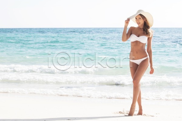 섹시 행복 여자 한명 JPG 포토 해외이미지 날씬함 모델 물 미소(표정) 바다 비키니 서기 서핑 선탠 수평선 신체 여름(계절) 하늘 해외202004 해외202105 휴가 휴양지 흰색