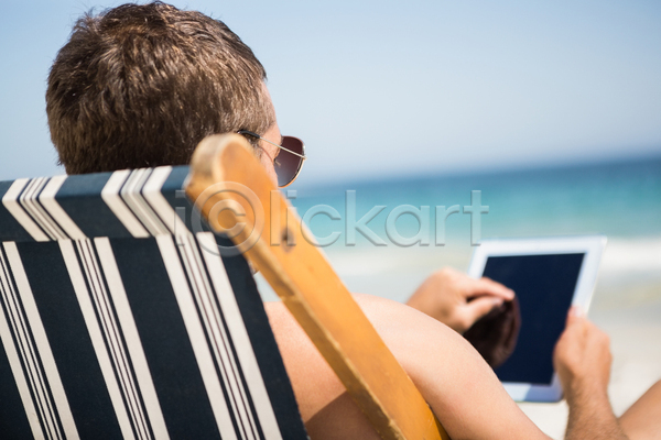 자유 평화 휴식 30대 남자 백인 사람없음 성인 JPG 포토 해외이미지 도피 맑음 모래 바다 앉기 알약 야외 야외의자 여름(계절) 연결 태블릿 터치 터치스크린 해외202105 휴가