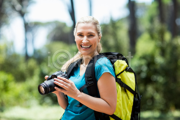 행복 40대 백인 사람없음 여자 중년 JPG 포토 해외이미지 건강 걷기 공원 금발 나무 도전 라이프스타일 모험가 미소(표정) 배낭 시골 야외 자국 자연 잔디 장비 초록색 카메라 탐험 포즈 풍경(경치) 하이킹 해외202105 환경