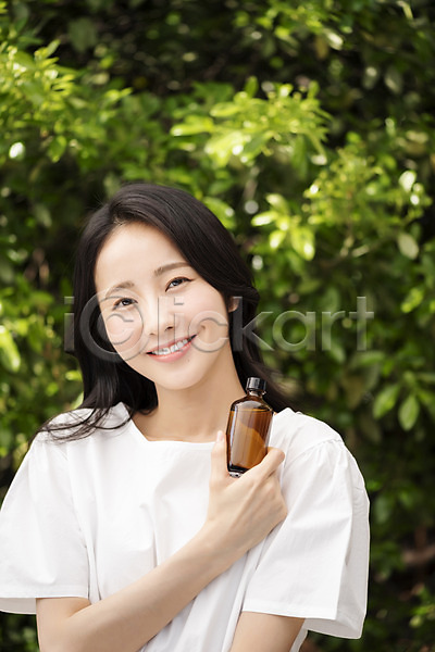 20대 성인 성인여자한명만 여자 한국인 한명 JPG 아웃포커스 앞모습 포토 나뭇잎 내추럴 들기 미소(표정) 뷰티 상반신 야외 응시 의료성형뷰티 주간 화장품