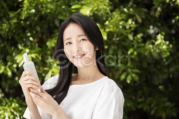 20대 성인 성인여자한명만 여자 한국인 한명 JPG 아웃포커스 앞모습 포토 나뭇잎 내추럴 들기 미소(표정) 뷰티 상반신 야외 응시 의료성형뷰티 주간 화장품