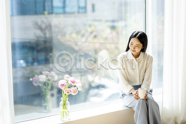휴식 20대 성인 성인여자한명만 여자 한국인 한명 JPG 앞모습 포토 꽃병 라넌큘러스 머그컵 미소(표정) 뷰티 상반신 실내 싱글라이프 앉기 우먼라이프 응시 의료성형뷰티 주간 창가 창문