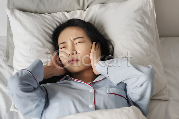 20대 성인 성인여자한명만 여자 한국인 한명 JPG 앞모습 포토 귀막기 눈감음 베개 상반신 시끄러움 실내 싱글라이프 우먼라이프 잠옷 찡그림 층간소음