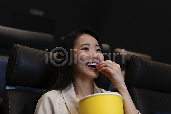 20대 성인 성인여자한명만 여자 한국인 한명 JPG 옆모습 포토 공공장소 들기 먹기 상반신 실내 앉기 어둠 영화관 영화관람 웃음 팝콘 혼영