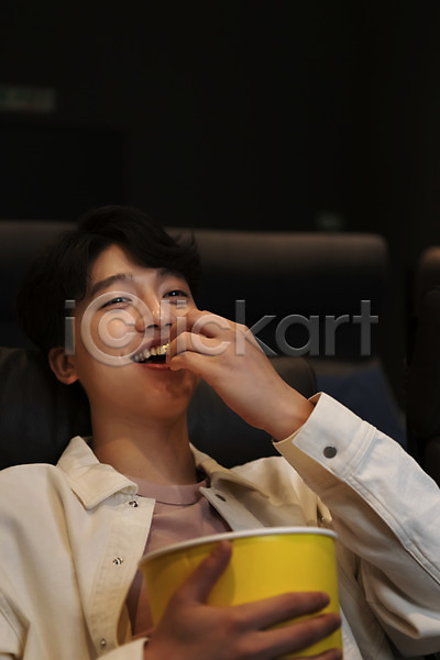 20대 남자 성인 성인남자한명만 한국인 한명 JPG 앞모습 포토 공공장소 들기 먹기 미소(표정) 상반신 실내 앉기 어둠 영화관 영화관람 팝콘 혼영