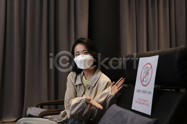 20대 성인 성인여자한명만 여자 한국인 한명 JPG 앞모습 포토 가리킴 공공시설 공공장소 마스크 방역지침 사회적거리두기 상반신 생활방역 실내 안전수칙 앉기 어둠 영화관 응시 주의안내문 코로나바이러스