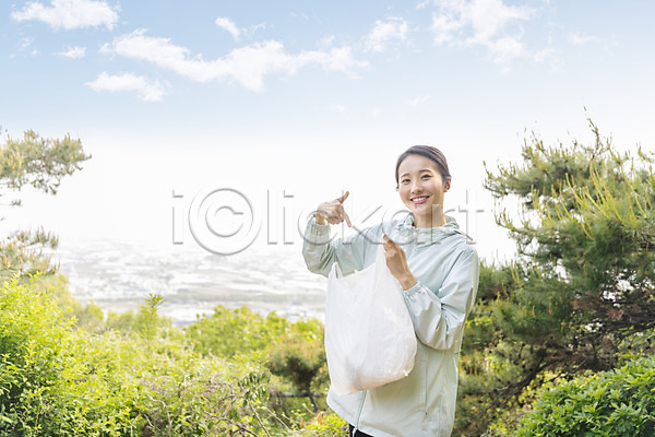 20대 성인 성인여자한명만 여자 한국인 한명 JPG 앞모습 포토 가리킴 그린캠페인 들기 미소(표정) 비닐봉투 산 상반신 쓰레기줍기 야외 우먼라이프 응시 자연보호 주간 친환경 플로깅 하늘