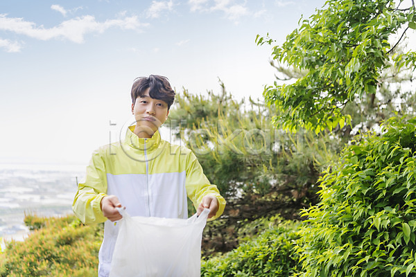 20대 남자 성인 성인남자한명만 한국인 한명 JPG 앞모습 포토 그린캠페인 들기 맨라이프 보여주기 비닐봉투 산 상반신 쓰레기 쓰레기줍기 야외 응시 자연보호 주간 친환경 플로깅 하늘