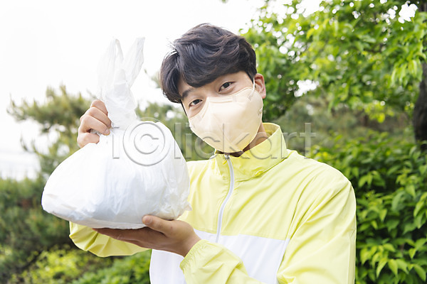 20대 남자 성인 성인남자한명만 한국인 한명 JPG 아웃포커스 앞모습 포토 그린캠페인 들기 마스크 맨라이프 보여주기 비닐봉투 산 상반신 쓰레기 쓰레기줍기 야외 응시 자연보호 주간 친환경 플로깅