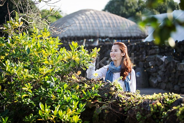 여유 휴식 20대 사람 성인 성인여자한명만 여자 한국인 한명 JPG 앞모습 포토 나무 나뭇잎 돌담 만지기 미소(표정) 상반신 서기 성읍민속촌 야외 여행 제주도 주간 한국