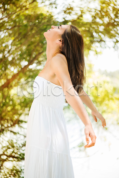 자유 행복 휴식 백인 사람 성인 여자 한명 JPG 포토 해외이미지 긍정 긴머리 드레스 서기 세로 야외 여름(계절) 올려보기 유행 자연 팔벌리기 해외202004 햇빛 흰색