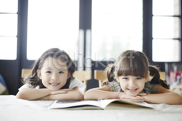 집중 호기심 두명 소녀만 여자 외국인 유치원생 한국인 JPG 앞모습 포토 미소(표정) 상반신 실내 앉기 엎드리기 책 친구 펼침