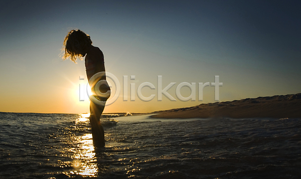 어린이 여자 한명 JPG 실루엣 포토 해외이미지 광선 노란색 모래 물 물결 바다 바닥 백그라운드 소금물 오렌지 일몰 자연 태양 파도 파란색 표면 플로리다 하늘 해외202004 환경 황금