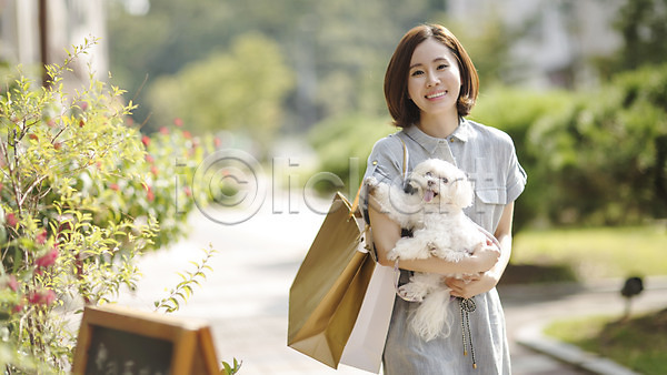 산책 여유 30대 성인 성인여자한명만 여자 여자만 한국인 한명 JPG 앞모습 포토 강아지 거리 미소(표정) 반려 상반신 서기 쇼핑 쇼핑백 야외 우먼라이프 주간 펫팸족 한마리