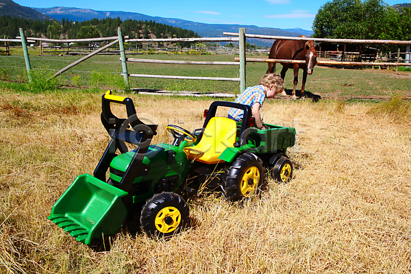 남자 백인 사람 소년 어린이 한명 JPG 포토 해외이미지 금발 노란색 놀이 농부 농업 농장 라이프스타일 밭 밭일 볏짚 부츠 시골 야외 여름(계절) 자연 작업 장난 장비 청바지 초록색 트랙터 해외202004
