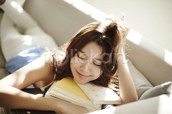 휴식 20대 성인 성인여자한명만 여자 한국인 한명 JPG 앞모습 포토 거실 눈감음 미소(표정) 상반신 생각 소파 스튜디오촬영 실내 싱글라이프 엎드리기 책