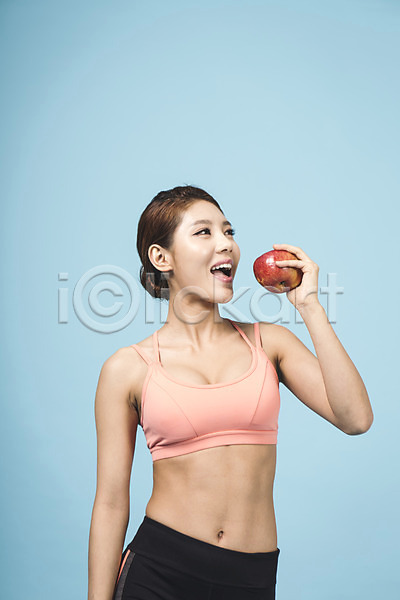 20대 성인 성인여자한명만 여자 청년여자한명만 한국인 한명 JPG 앞모습 포토 다이어트 들기 먹기 사과(과일) 상반신 스튜디오촬영 실내 운동복 파란배경