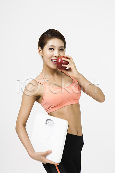 20대 성인 성인여자한명만 여자 청년여자한명만 한국인 한명 JPG 옆모습 포토 다이어트 들기 먹기 미소(표정) 사과(과일) 상반신 서기 스튜디오촬영 실내 운동복 체중계 흰배경