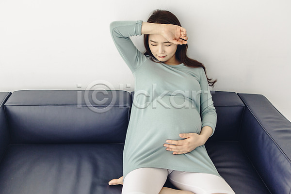 고통 괴로움 불쾌함 20대 성인 성인여자한명만 여자 청년여자한명만 한국인 한명 JPG 앞모습 포토 눈감음 상반신 소파 실내 앉기 임산부 임신 진통 찡그림