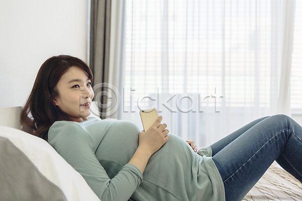 20대 성인 성인여자한명만 여자 청년여자한명만 한국인 한명 JPG 옆모습 포토 눕기 들기 미소(표정) 상반신 스마트폰 실내 임산부 임신 침대