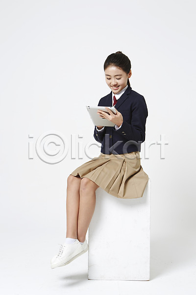 십대여자한명만 여자 중학생 청소년 한국인 한명 JPG 옆모습 포토 교복 내려보기 들기 미소(표정) 스튜디오촬영 실내 앉기 여중생 여학생 운동화 전신 태블릿 흰배경