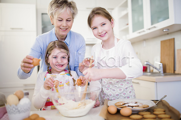 요리중 60대 백인 성인 세명 어린이 여자 유치원생 초등학생 JPG 앞모습 포토 계란 미소(표정) 부활절 상반신 손녀 실내 앞치마 요리 주방 할머니