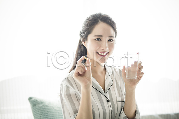 휴식 20대 성인 성인여자한명만 여자 여자만 한국인 한명 JPG 앞모습 포토 건강 들기 물 미소(표정) 뷰티 비타민(영양소) 상반신 스튜디오촬영 실내 아침 앉기 알약 우먼라이프 의료성형뷰티