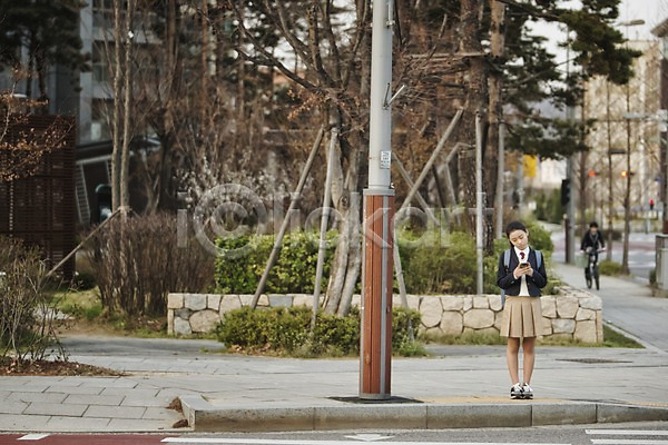 10대 십대여자한명만 여자 청소년 한국인 한명 JPG 앞모습 포토 거리 교복 기다림 등하교 서기 스마트폰 십대라이프스타일 야외 여학생 전신 주간 횡단보도